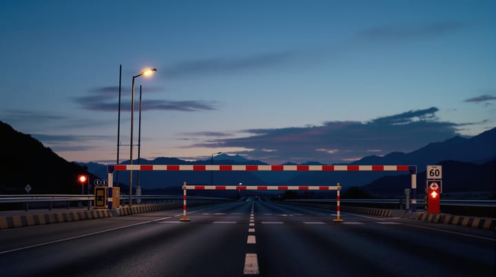 A border crossing barrier at dusk