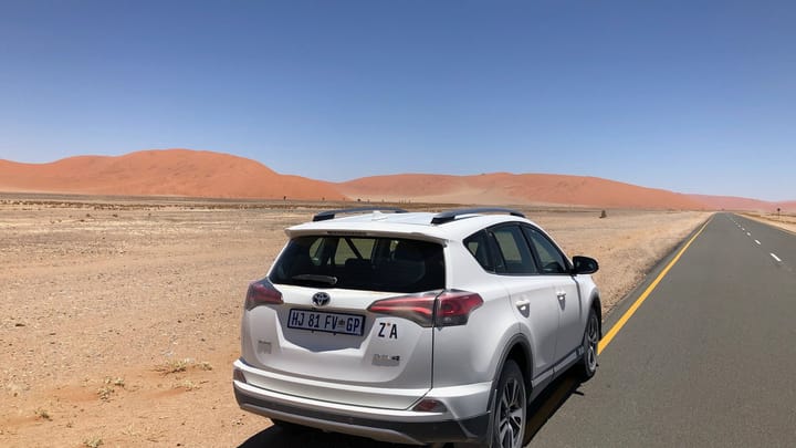 A rental SUV on a highway through the Namib desert