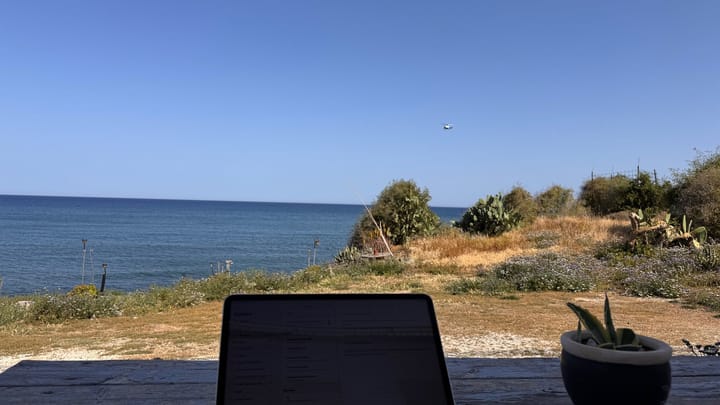 A laptop on a terrace table facing the sea at Pomos, Cyprus