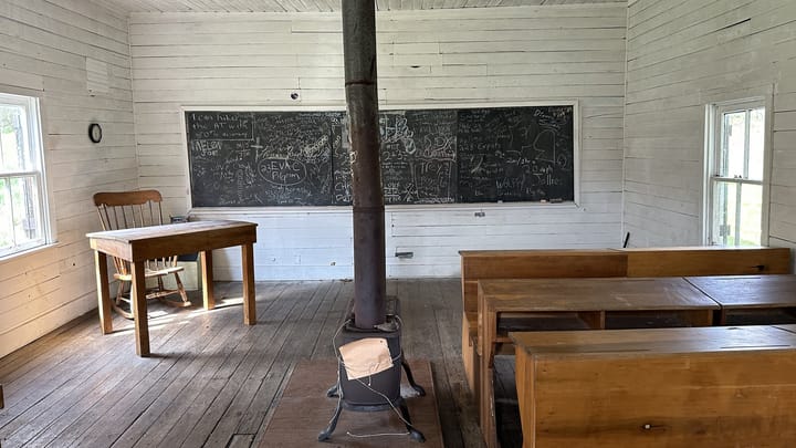 An empty one-room schoolhouse with chalkboards
